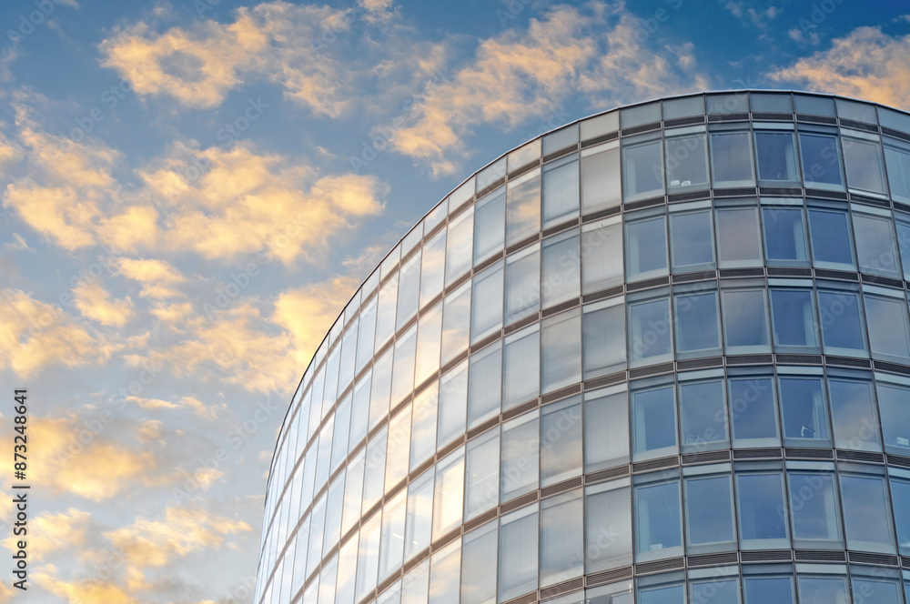 Office building block with rounded corners in Brussels under a blue sky with fluffy clouds Office building block with rounded corners in Brussels under a blue sky with fluffy clouds