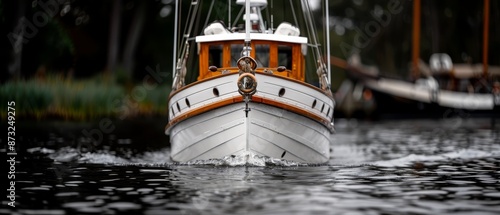  A white and orange boat floating on a body of water Behind it, other boats dot the surface Trees line the backdrop