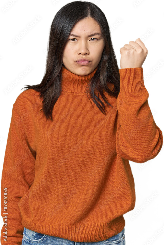 Young Chinese woman showing fist to camera, aggressive facial expression. Young Chinese woman showing fist to camera, aggressive facial expression.
