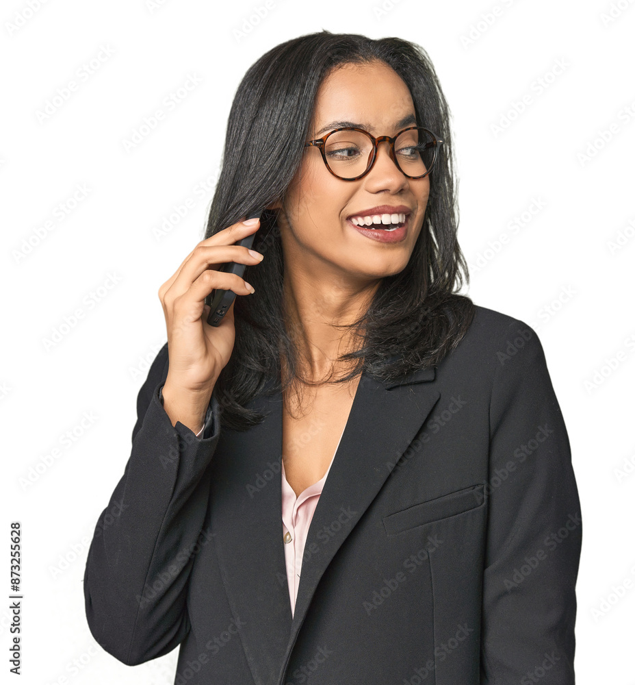 Latina in suit with phone in studio looks aside smiling, cheerful and pleasant. Latina in suit with phone in studio looks aside smiling, cheerful and pleasant.