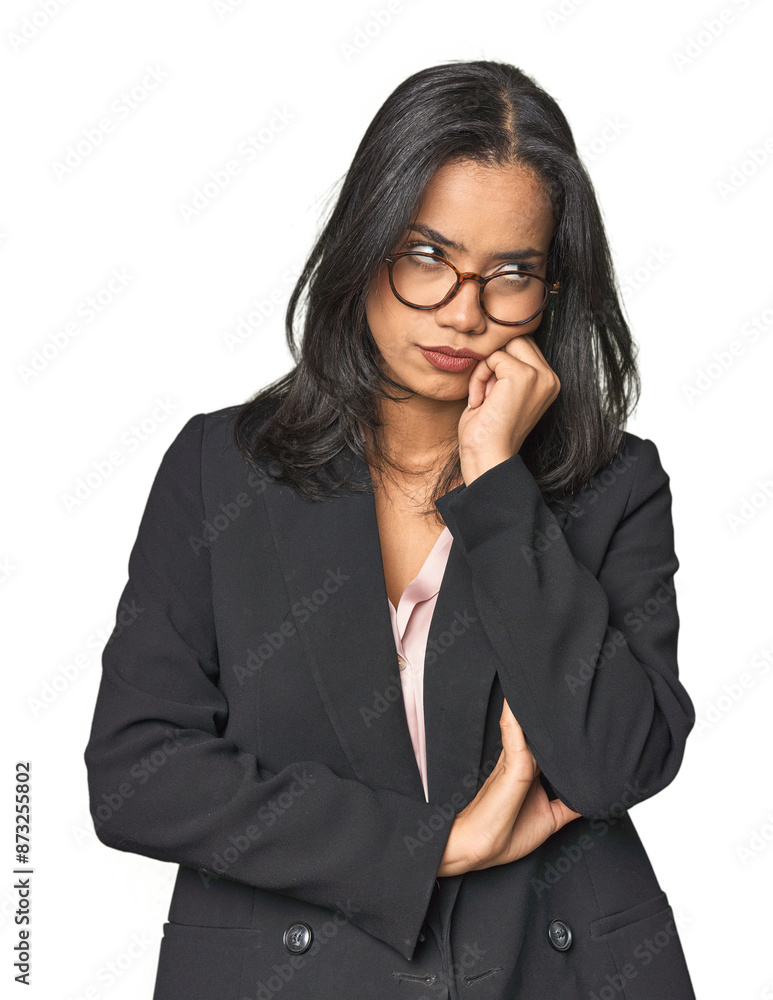Young Latina professional in studio who feels sad and pensive, looking at copy space. Young Latina professional in studio who feels sad and pensive, looking at copy space.