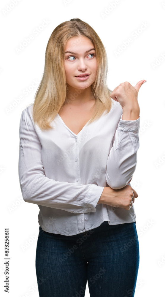 Young caucasian woman over isolated background smiling with happy face looking and pointing to the side with thumb up. Young caucasian woman over isolated background smiling with happy face looking and pointing to the side with thumb up.