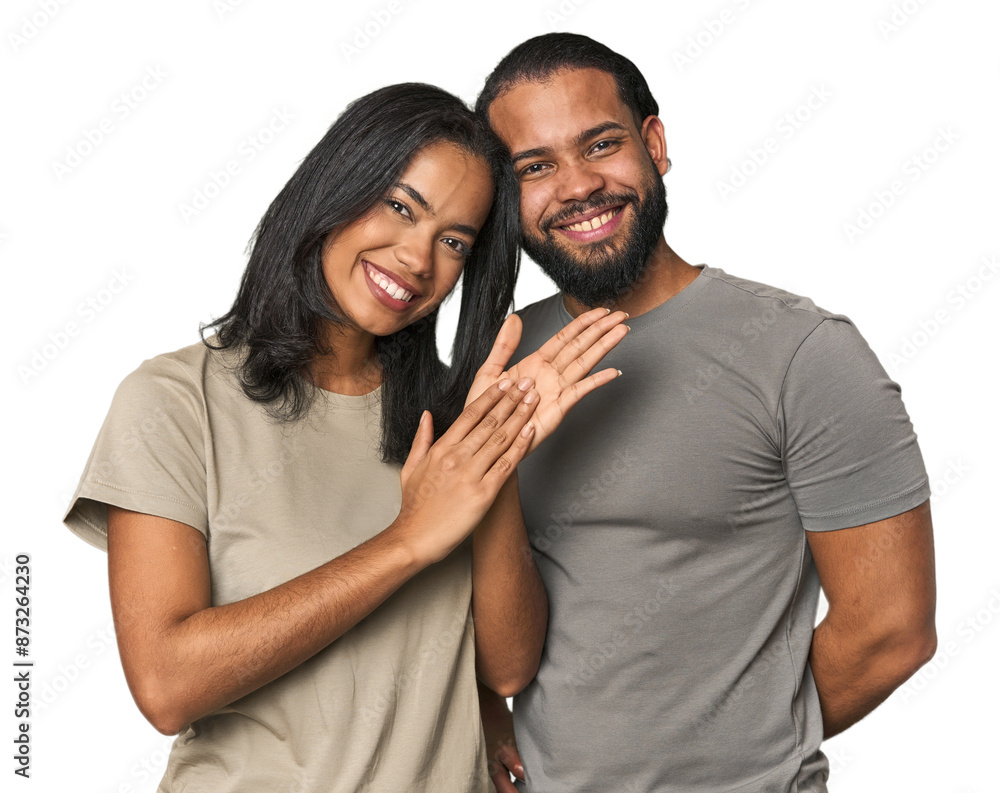 Naklejka premium Young Latino couple in studio feeling energetic and comfortable, rubbing hands confident.