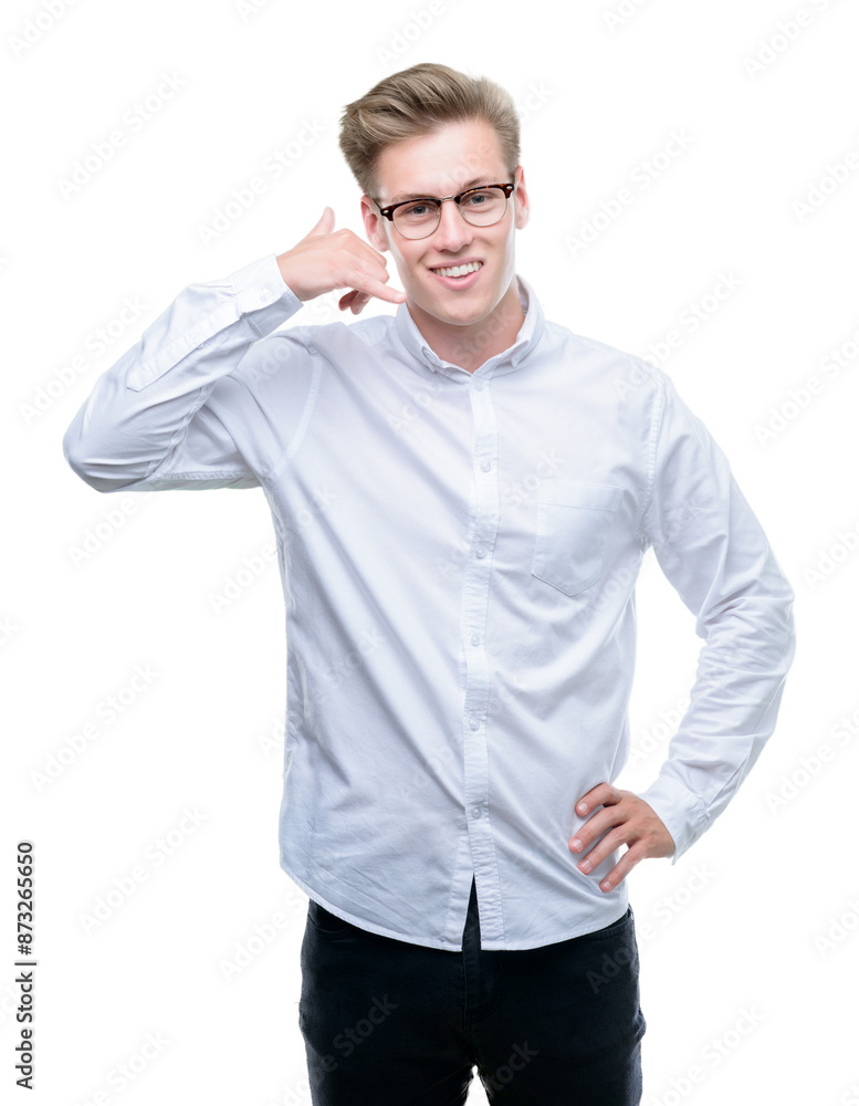 Young handsome blond man smiling doing phone gesture with hand and fingers like talking on the telephone. Communicating concepts. Young handsome blond man smiling doing phone gesture with hand and fingers like talking on the telephone. Communicating concepts.