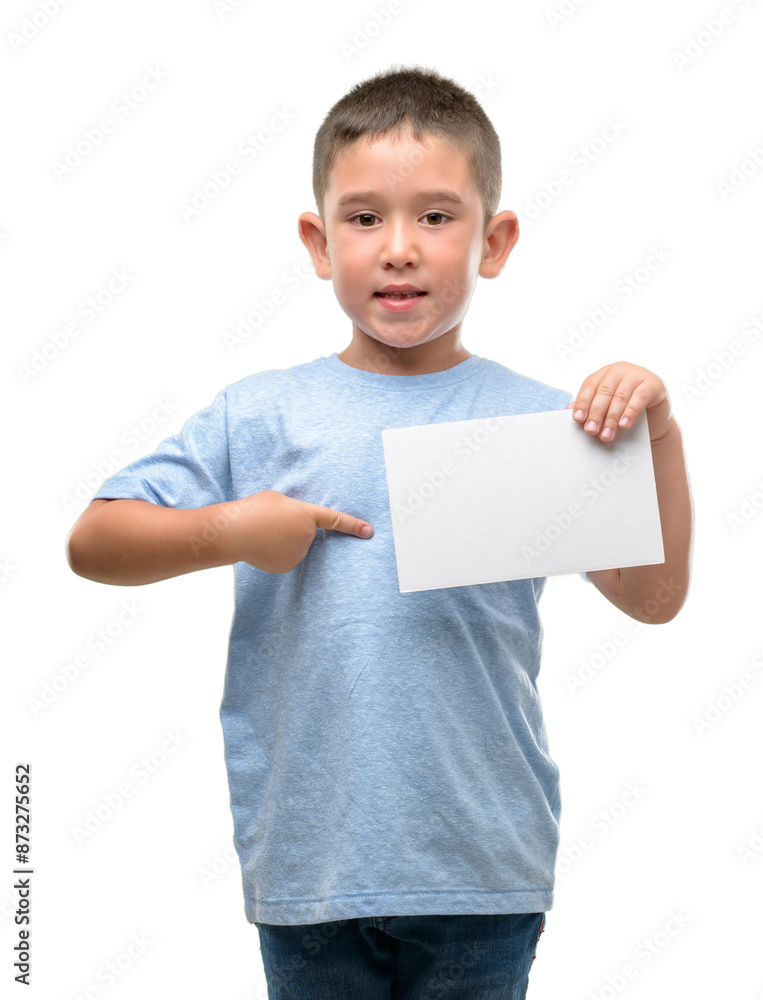 Dark haired little child holding a blank card with surprise face pointing finger to himself Dark haired little child holding a blank card with surprise face pointing finger to himself