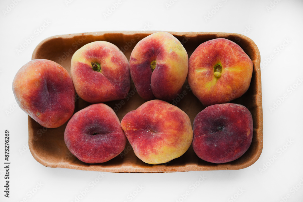 Flat peaches on a white background. Peaches in a package. Flat peaches on a white background. Peaches in a package.