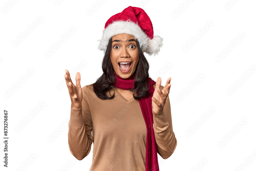 Filipino in Christmas attire and Santa hat receiving a pleasant surprise, excited and raising hands. Filipino in Christmas attire and Santa hat receiving a pleasant surprise, excited and raising hands.