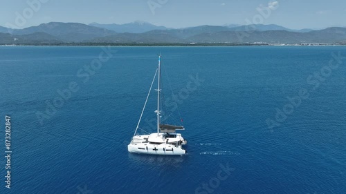 Aerial view of a moored yacht boat in beautiful calm sea bay with turquoise water near Fethiye, Turkey. Full circle around luxury