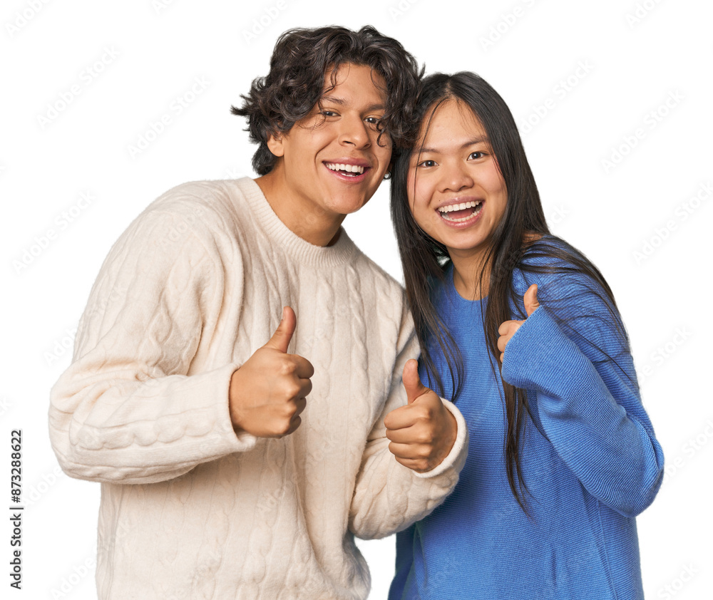Young interracial couple in studio raising both thumbs up, smiling and confident. Young interracial couple in studio raising both thumbs up, smiling and confident.