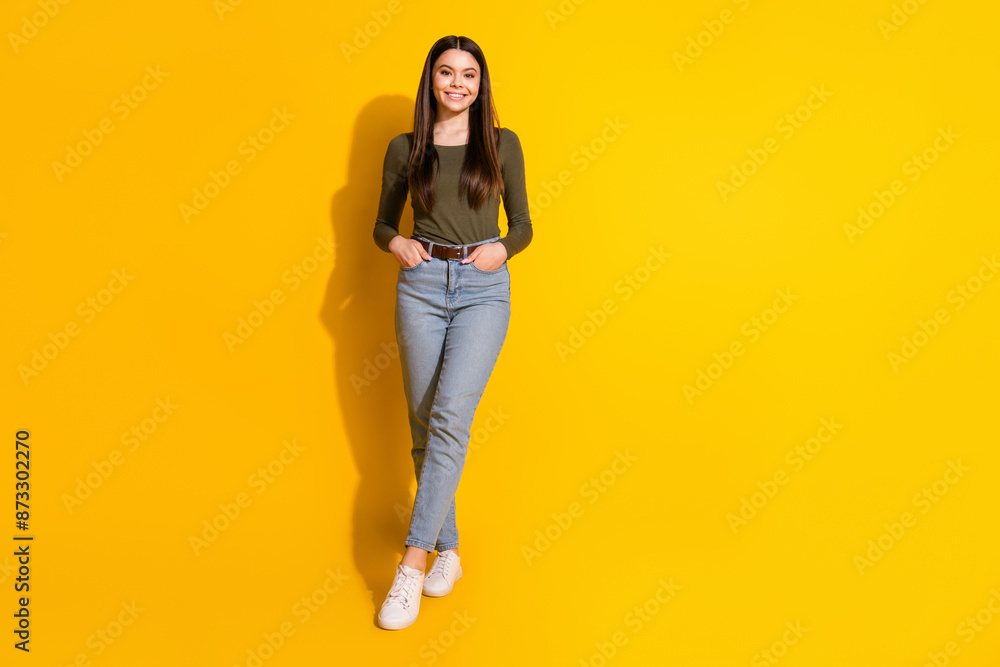 Full length photo of lovely teen lady posing model dressed stylish khaki garment isolated on yellow color background Full length photo of lovely teen lady posing model dressed stylish khaki garment isolated on yellow color background