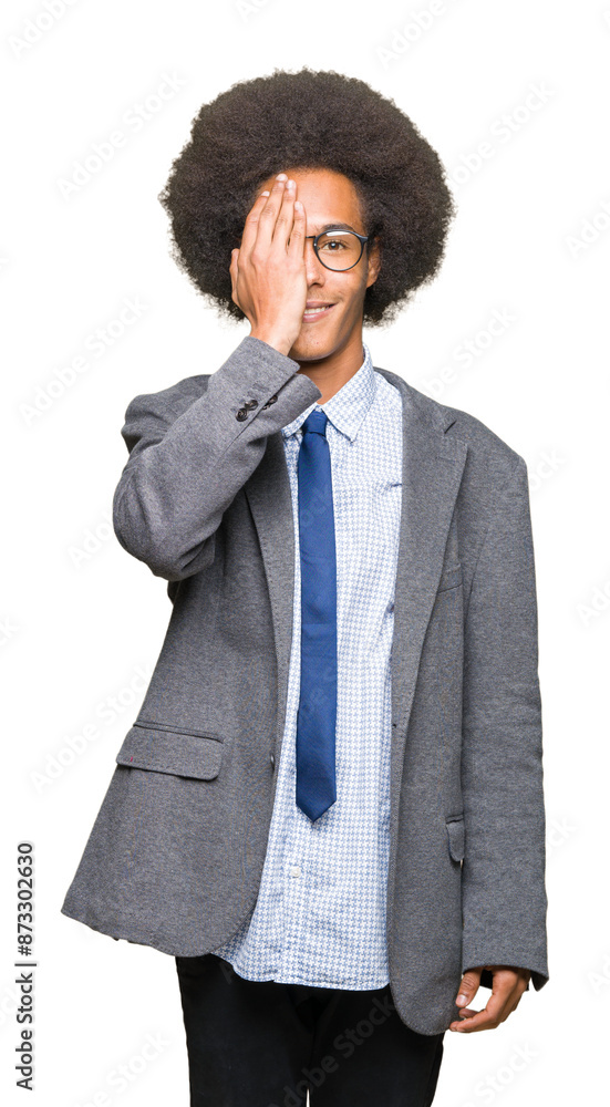 Young african american business man with afro hair wearing glasses covering one eye with hand with confident smile on face and surprise emotion. Young african american business man with afro hair wearing glasses covering one eye with hand with confident smile on face and surprise emotion.