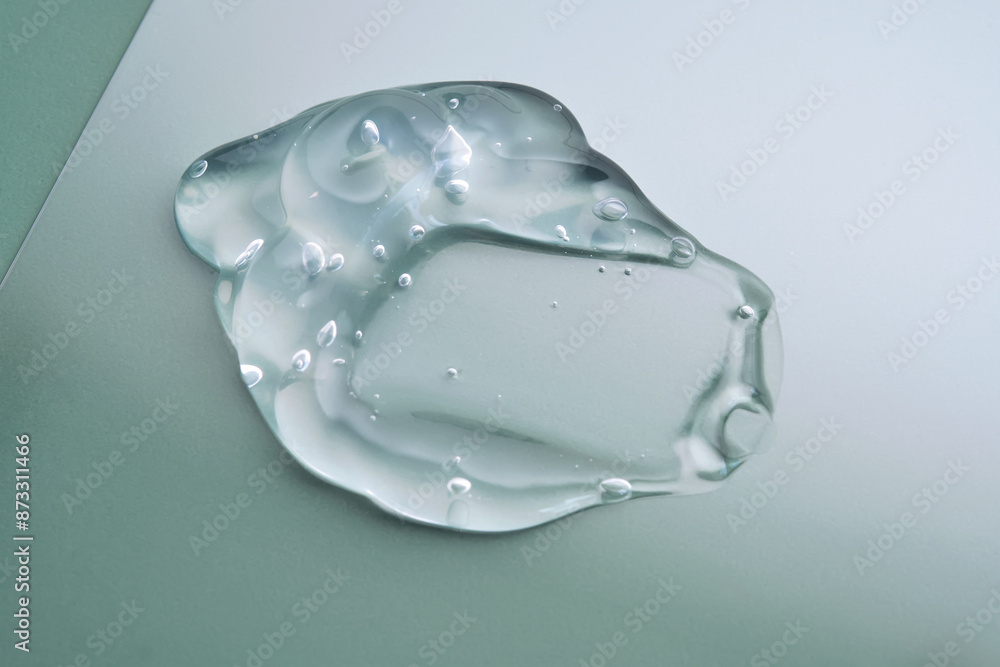 Texture of cosmetic hyaluronic gel or gel lubricant on a green background. Texture of cosmetic hyaluronic gel or gel lubricant on a green background.
