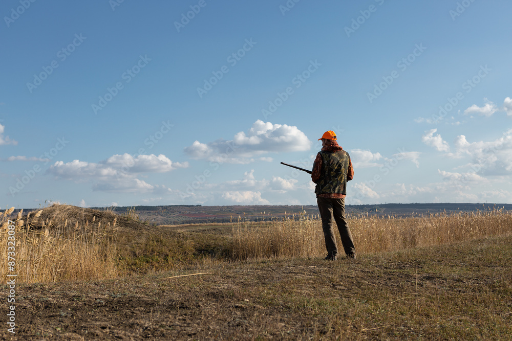custom made wallpaper toronto digitalMature man hunter with gun while walking on field.