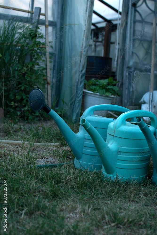 Group of a watering cans near the greenhouse Group of a watering cans near the greenhouse