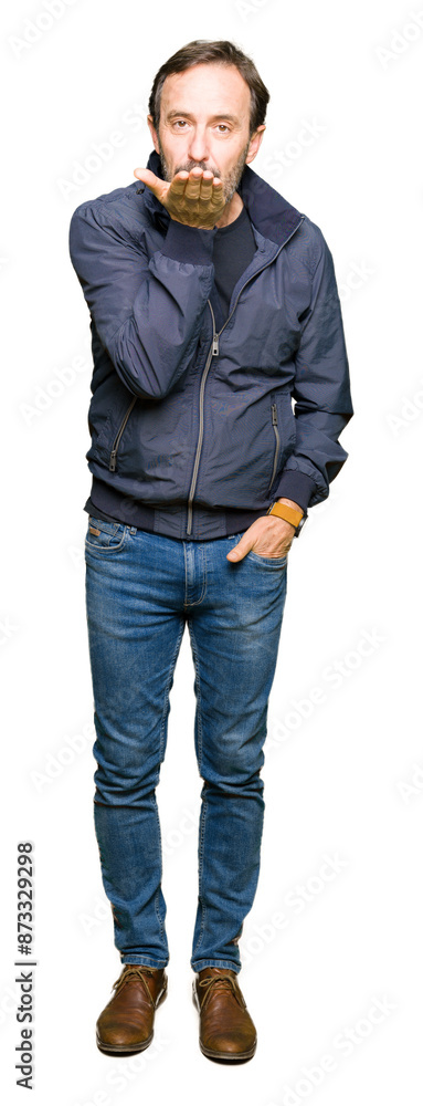 Middle age handsome man wearing a jacket looking at the camera blowing a kiss with hand on air being lovely and sexy. Love expression. Middle age handsome man wearing a jacket looking at the camera blowing a kiss with hand on air being lovely and sexy. Love expression.