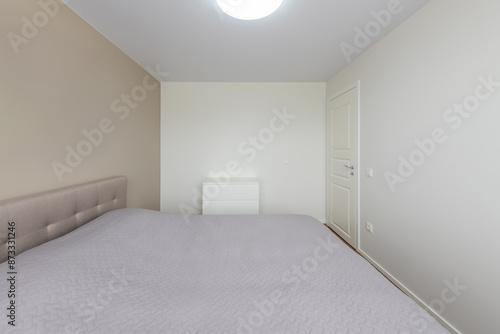 Minimalism Children, Young Adult Living Room Interior. Chest of Drawers. Gray Blanket on the Bed. LED Light. White Door