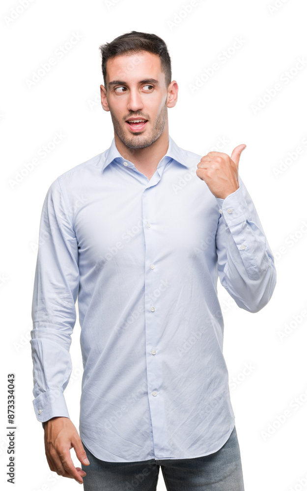Handsome young businessman smiling with happy face looking and pointing to the side with thumb up. Handsome young businessman smiling with happy face looking and pointing to the side with thumb up.