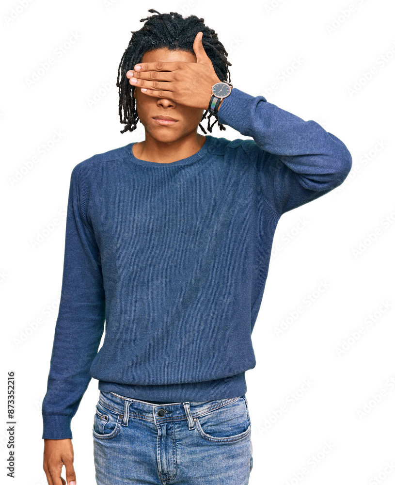 Young african american man wearing casual winter sweater covering eyes with hand, looking serious and sad. sightless, hiding and rejection concept Young african american man wearing casual winter sweater covering eyes with hand, looking serious and sad. sightless, hiding and rejection concept