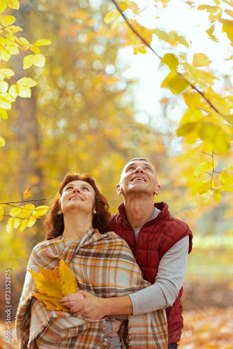 happy romantic couple in park with autumn leafs looking up © Alliance
