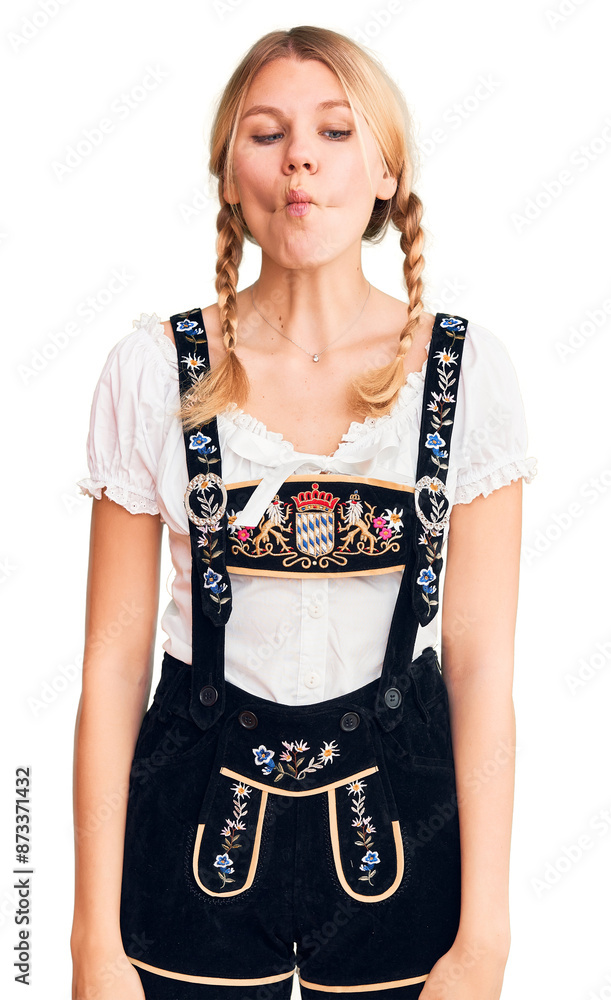 Young beautiful blonde woman wearing oktoberfest dress making fish face with lips, crazy and comical gesture. funny expression. Young beautiful blonde woman wearing oktoberfest dress making fish face with lips, crazy and comical gesture. funny expression.