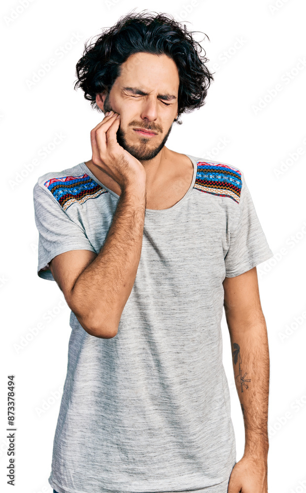Young hispanic man wearing casual t shirt touching mouth with hand with painful expression because of toothache or dental illness on teeth. dentist Young hispanic man wearing casual t shirt touching mouth with hand with painful expression because of toothache or dental illness on teeth. dentist