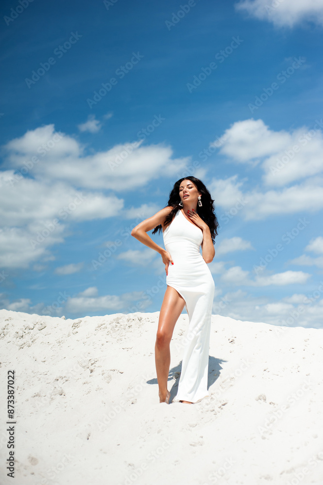 Perfect fashion vogue woman on resort wearing white dress and walking on sand beach Perfect fashion vogue woman on resort wearing white dress and walking on sand beach