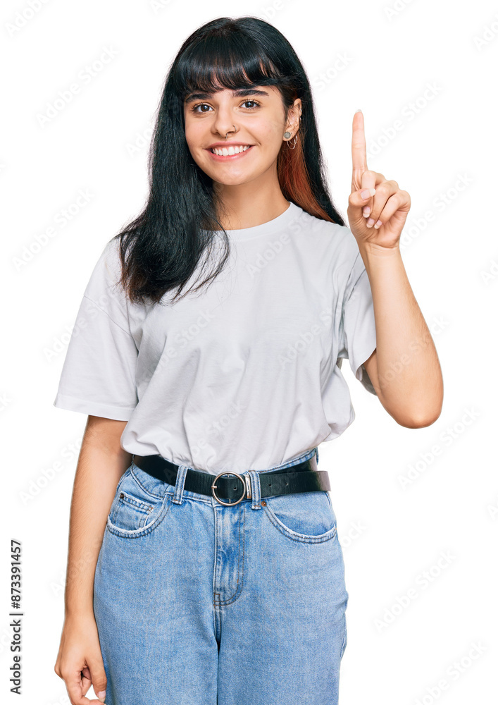 Young hispanic girl wearing casual clothes showing and pointing up with finger number one while smiling confident and happy. Young hispanic girl wearing casual clothes showing and pointing up with finger number one while smiling confident and happy.