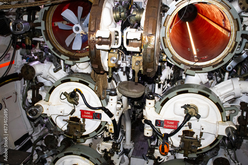 Explore the intricate world of an Australian submarine in Sydney, NSW. This captivating 
photo captures the essence of a small control room adorned with a multitude of controls, meters, and gauges.