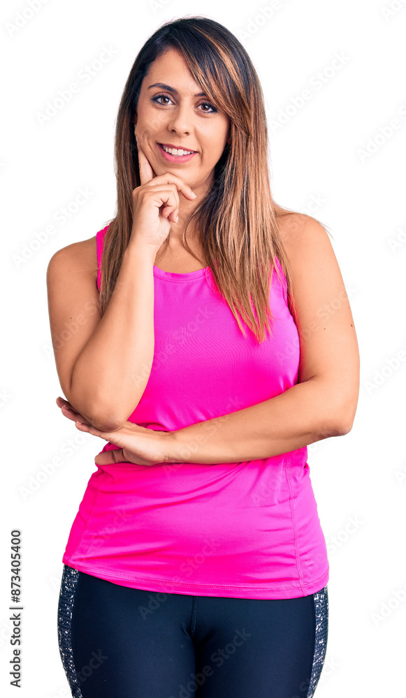 Young beautiful woman wearing sportswear looking confident at the camera with smile with crossed arms and hand raised on chin. thinking positive. Young beautiful woman wearing sportswear looking confident at the camera with smile with crossed arms and hand raised on chin. thinking positive.