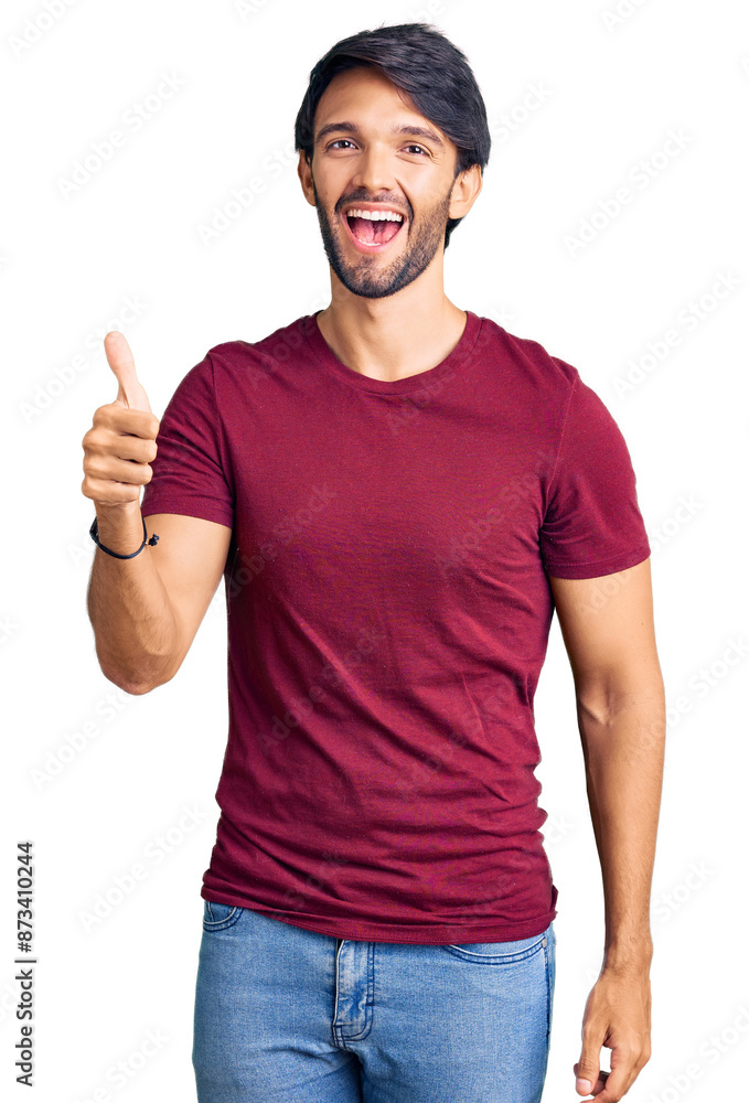 Handsome hispanic man wearing casual clothes doing happy thumbs up gesture with hand. approving expression looking at the camera showing success. Handsome hispanic man wearing casual clothes doing happy thumbs up gesture with hand. approving expression looking at the camera showing success.