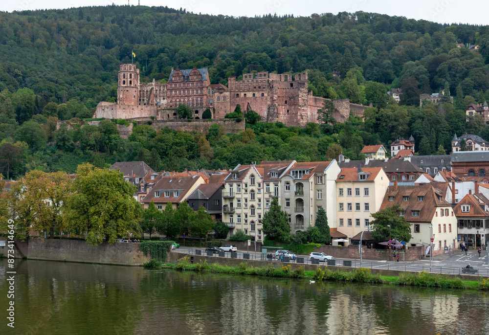 A city with a river running through it and a castle in the background A city with a river running through it and a castle in the background