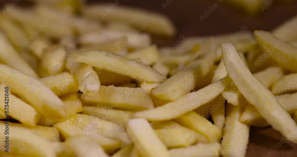 frozen long French fries on paper, defrosting potatoes cut into thin slices frozen long French fries on paper, defrosting potatoes cut into thin slices