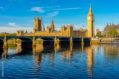 Houses of parliament with Big Ben tower and Westminster bridge reflected in Thames river, London, UK