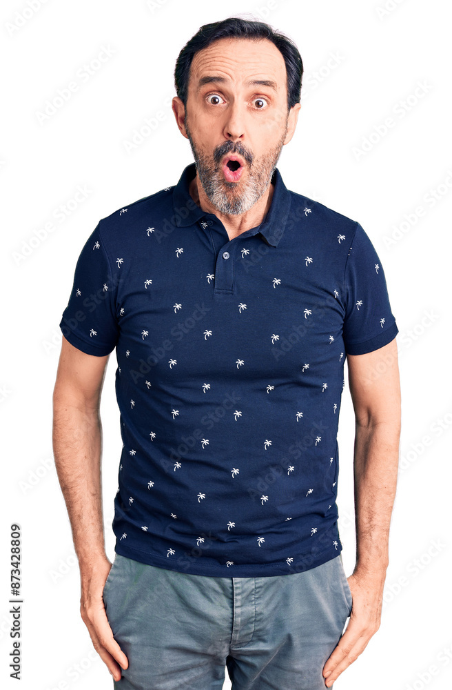 Obraz premium Middle age handsome man wearing casual polo scared and amazed with open mouth for surprise, disbelief face