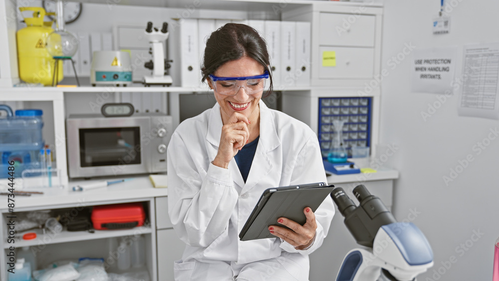 Smiling woman scientist using tablet in laboratory setting, showcasing healthcare, research, and technology. Smiling woman scientist using tablet in laboratory setting, showcasing healthcare, research, and technology.