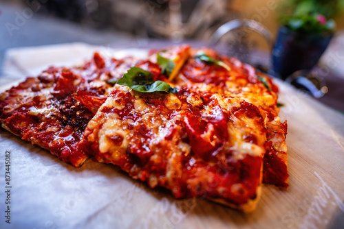 Board with pieces of delicious pizza Diablo on wooden table, side selective focus view