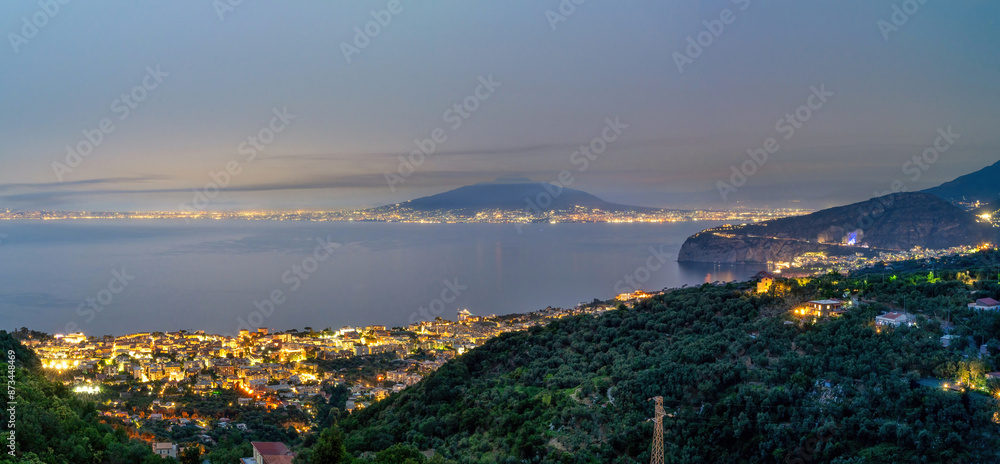Panoramic night view cityscape of Sorrento at night against mount vesuvius volcano in the center, Sorrento, Amalfi Coast, UNESCO World Heritage Site, Campania, Italy, Europe