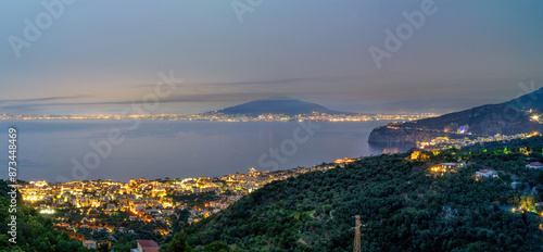 Panoramic night view cityscape of Sorrento at night against mount vesuvius volcano in the center, Sorrento, Amalfi Coast, UNESCO World Heritage Site, Campania, Italy, Europe
