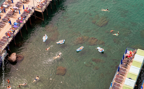 Obraz na płótnie Sorrento, Italy : Aerial view of People relaxing on the beach on the pier and swimming in the sea on inflatable air beds in Sorrento. w salonie