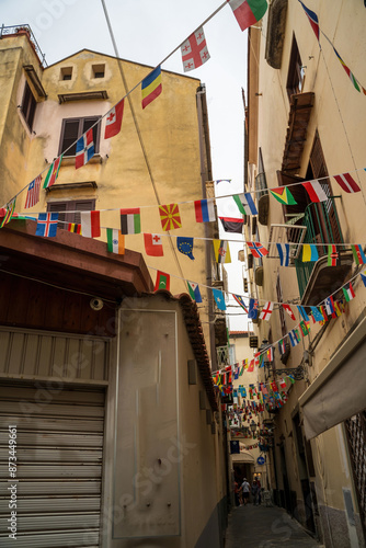 Sorrento, Italy - June 24, 2024: Narrow streets of Sorrento with shops and flags of different countries hanging on a rope