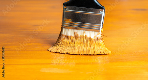 Photography Painting table with brown enamel, brush in hand close-up, painting wood furnitur