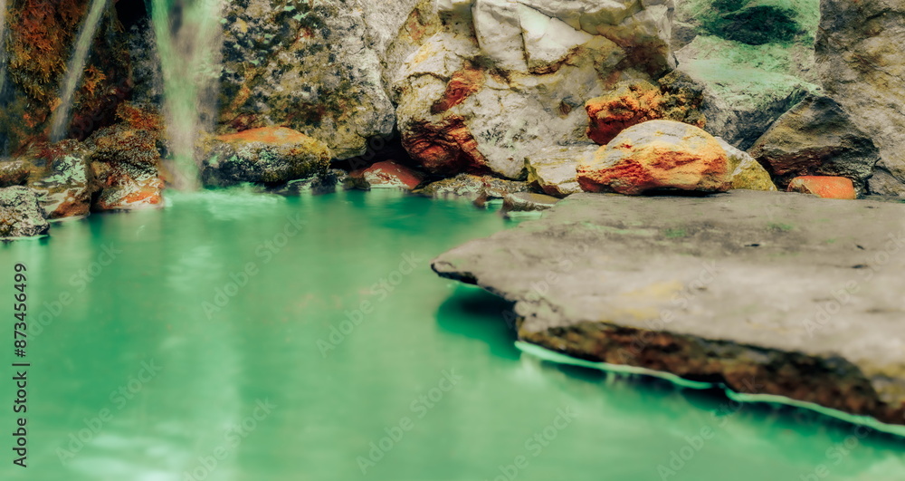 Fototapeta premium A Blurred Foreground Rock Shelf for a Product Display, Leading to a Depiction of a Contaminated waterfall with Toxic Rocks and Infected Moss Ecology.