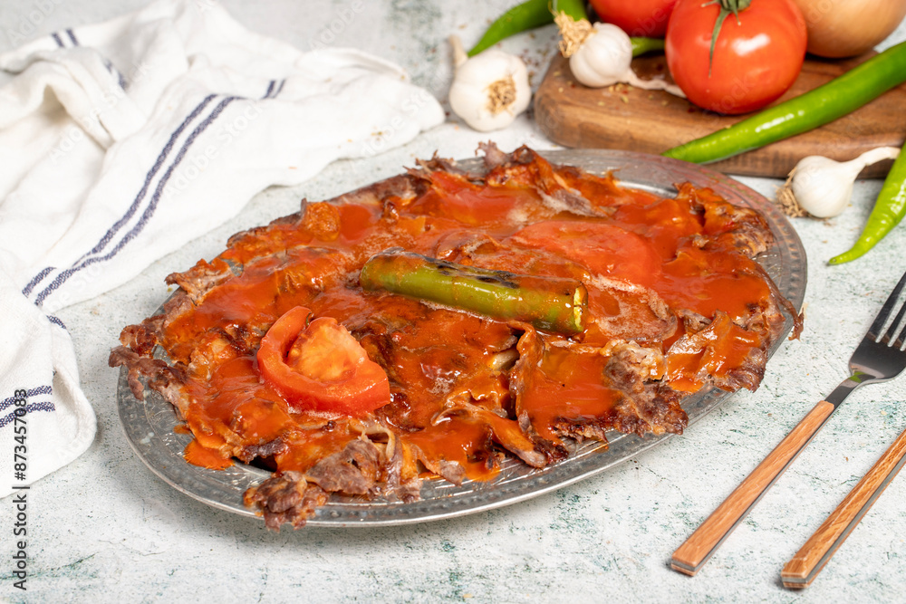 Iskender kebab. Traditional Turkish cuisine taste. Cooked iskender kebab with sauce and butter on a gray background. Close up Iskender kebab. Traditional Turkish cuisine taste. Cooked iskender kebab with sauce and butter on a gray background. Close up