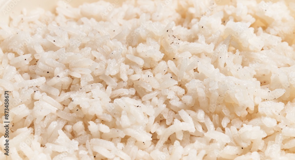 Close-up of steamed white rice grains sprinkled with pepper, indicating a culinary theme and food background Close-up of steamed white rice grains sprinkled with pepper, indicating a culinary theme and food background