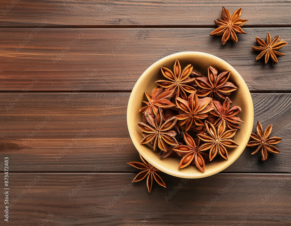Bowl with star anise on wooden background, top view and space for text Bowl with star anise on wooden background, top view and space for text