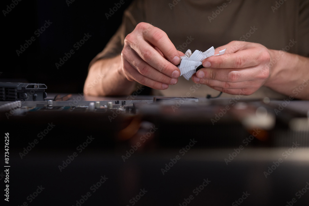 A technician is skillfully repairing a computer GPU fan with precision tools in a workshop A technician is skillfully repairing a computer GPU fan with precision tools in a workshop