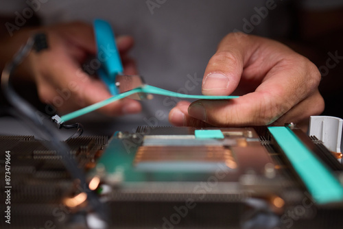 Technician assembling a GPU, focusing on installing computer hardware components