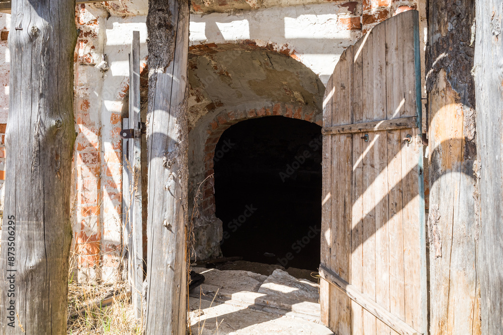 Abandoned entrance door to dungeon or basement. opened wooden doors cellar in ground Abandoned entrance door to dungeon or basement. opened wooden doors cellar in ground