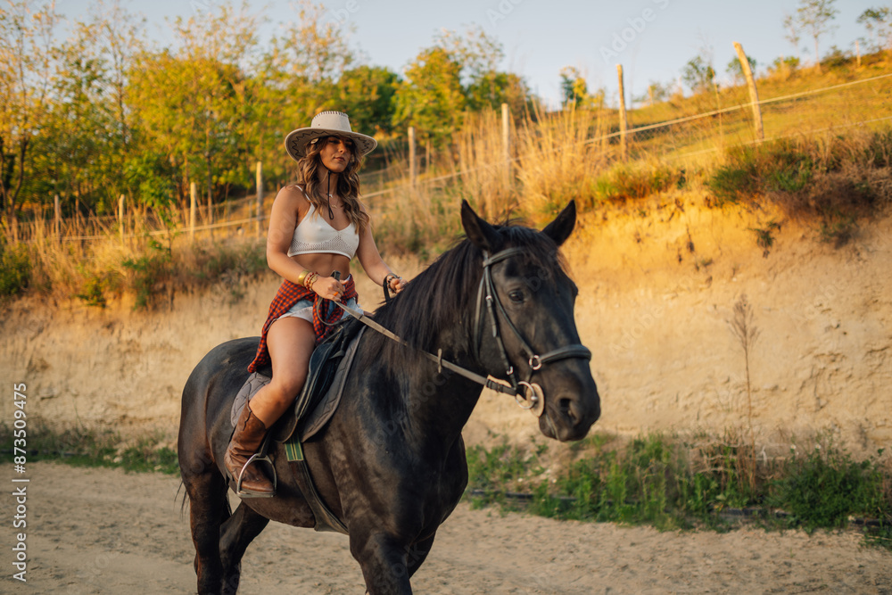 Young cowgirl is horseback riding at homestead on horse ranch. Young cowgirl is horseback riding at homestead on horse ranch.