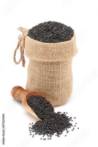 Close-up of Organic Black Sesame (Sesamum indicum) Seeds, in a jute bag and on a scoop, Isolated on a white background. photo